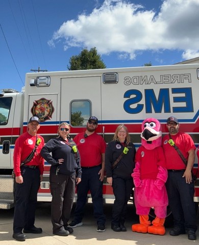 Firelands EMS crew with the Station 51 mascot in front of an ambulance